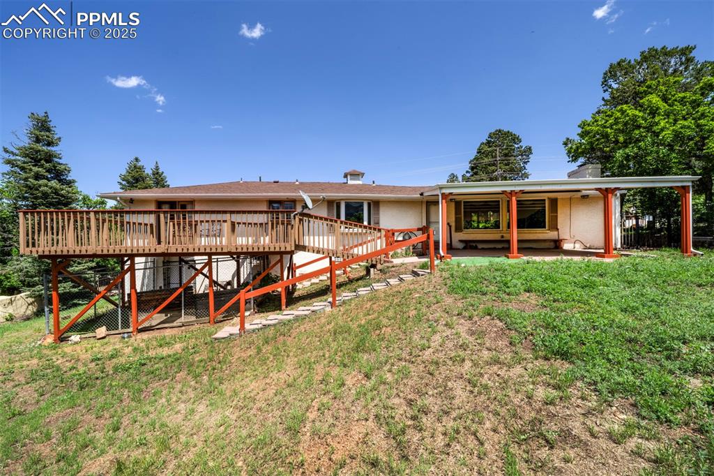 Image 45 of 49: Back of house featuring a deck, stairway, and a yard