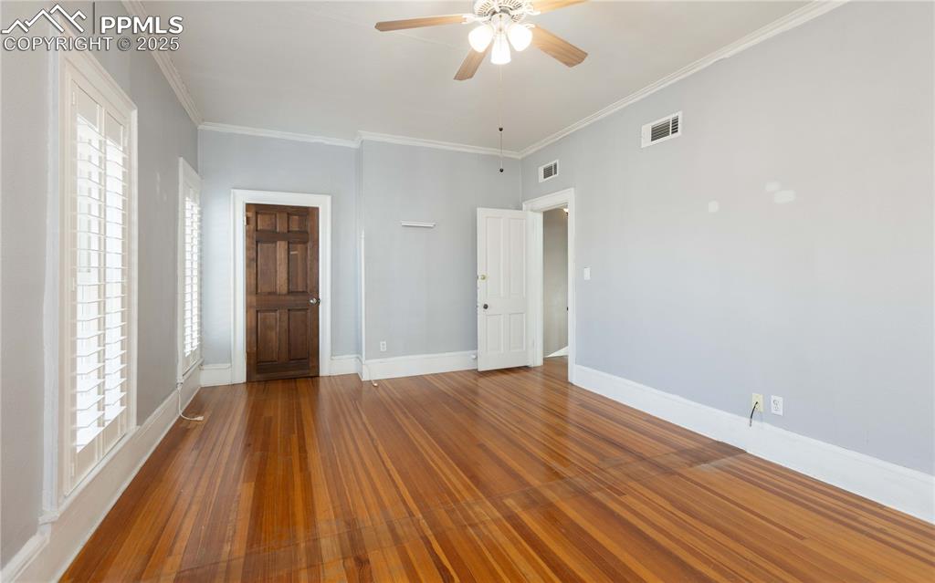 Image 15 of 31: Unfurnished bedroom with crown molding, ceiling fan, and hardwood / wood-st