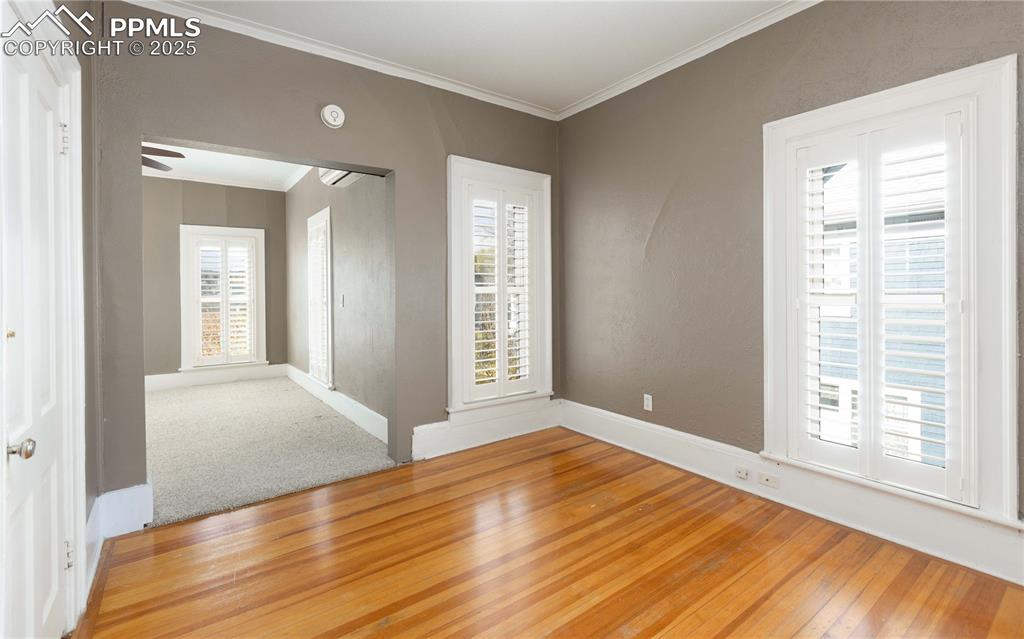 Image 16 of 31: Unfurnished room featuring plenty of natural light, crown molding, hardwood