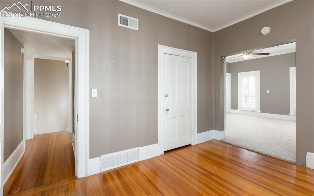 Image 17 of 31: Empty room with light wood-type flooring, ornamental molding, and ceiling f