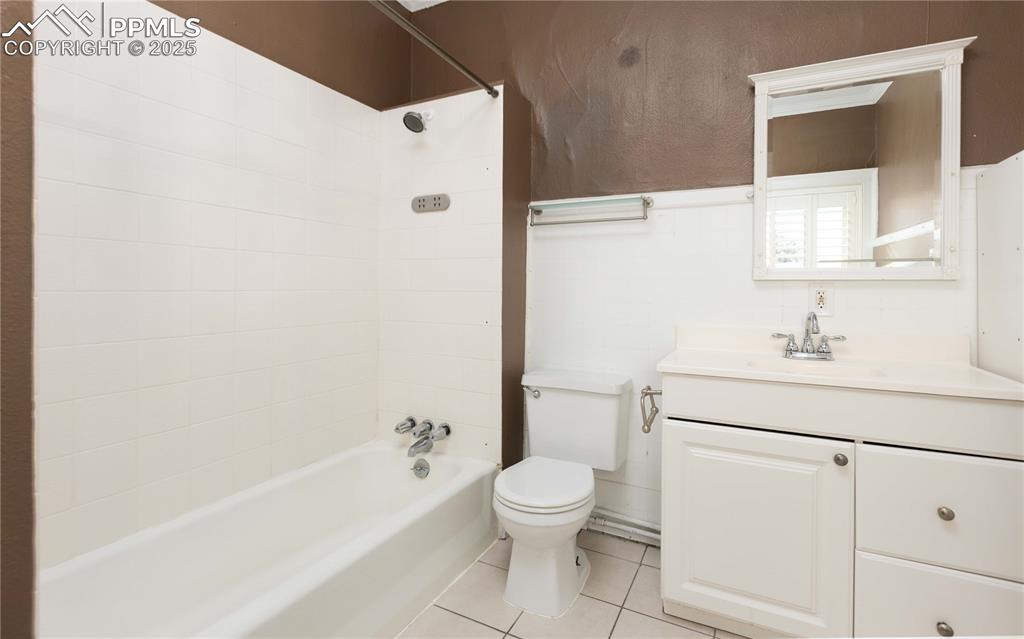 Image 20 of 31: Full bathroom featuring light tile patterned floors, vanity, and shower / t