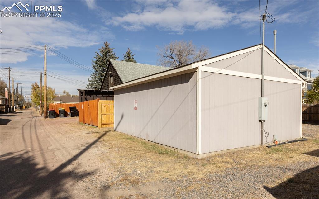 Image 24 of 31: View of property exterior featuring an outbuilding and roof with shingles