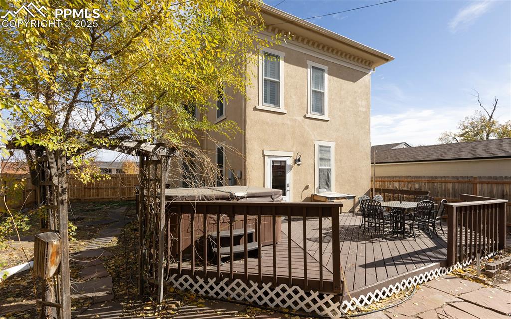 Image 28 of 31: Rear view of house featuring a fenced backyard, stucco siding, outdoor dini