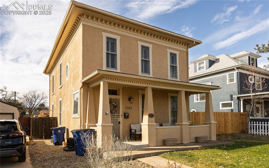 Image 3 of 31: Italianate home featuring covered porch and stucco siding
