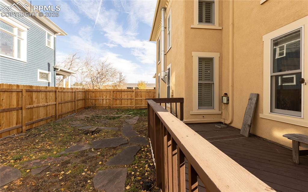 Image 30 of 31: Wooden deck with a fenced backyard