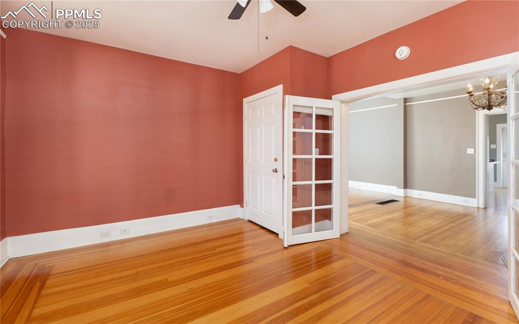 Image 8 of 31: Empty room with light wood-style floors, a chandelier, and ceiling fan