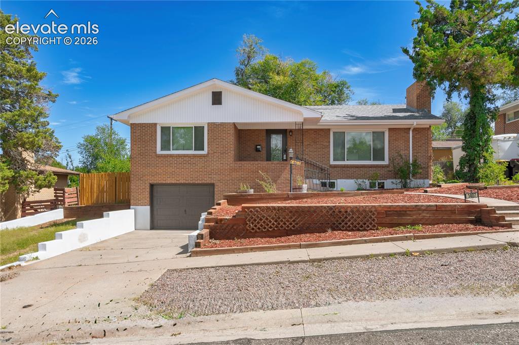 Image 1 of 36: Brick exterior with white trim, attached garage, concrete driveway, and tie