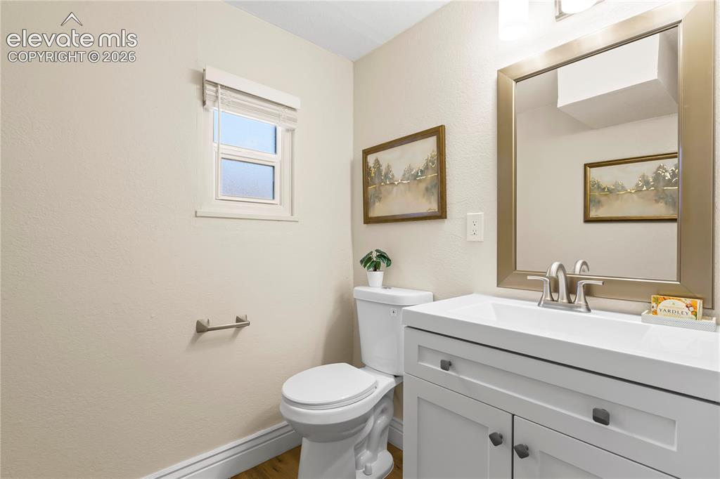 Image 13 of 36: Bathroom featuring a white vanity with integrated sink, brushed nickel fauc
