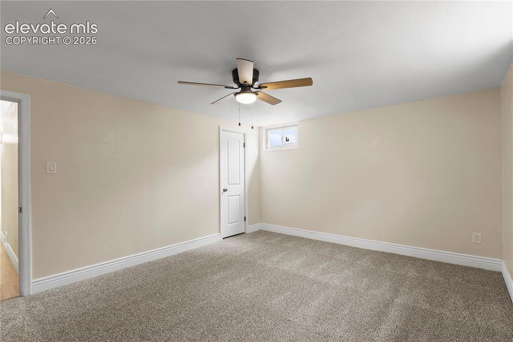 Image 20 of 36: Carpeted room with neutral wall tones and white baseboards