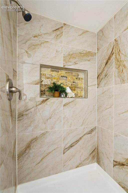 Image 22 of 36: Shower enclosure featuring large format porcelain tile with natural stone-l