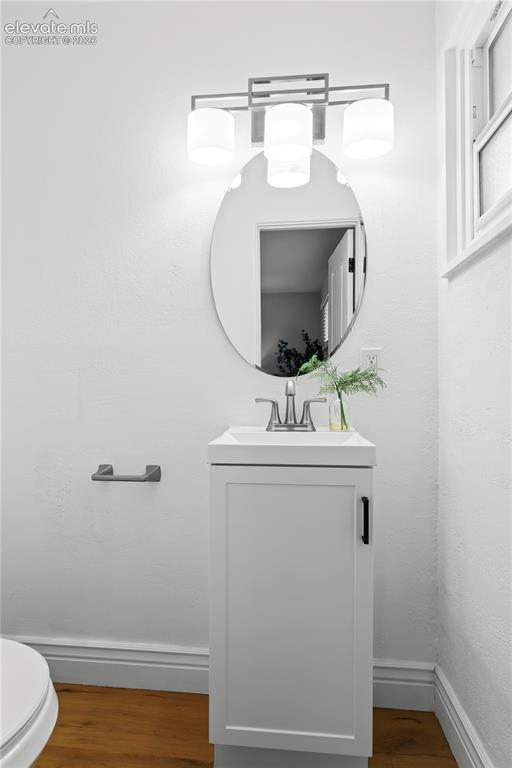 Image 23 of 36: White single-door vanity with a rectangular sink and brushed nickel faucet