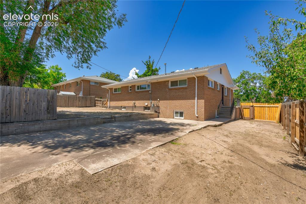 Image 27 of 36: Brick exterior featuring multiple windows and a white trim roofline