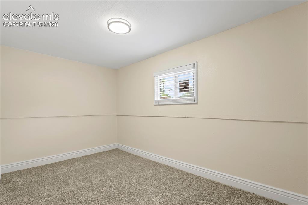 Image 34 of 36: Room featuring neutral wall tones, plush carpeting, a single window with bl