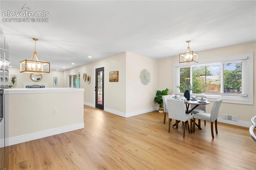Image 9 of 36: Open-concept living area featuring wood-finish flooring, recessed lighting,