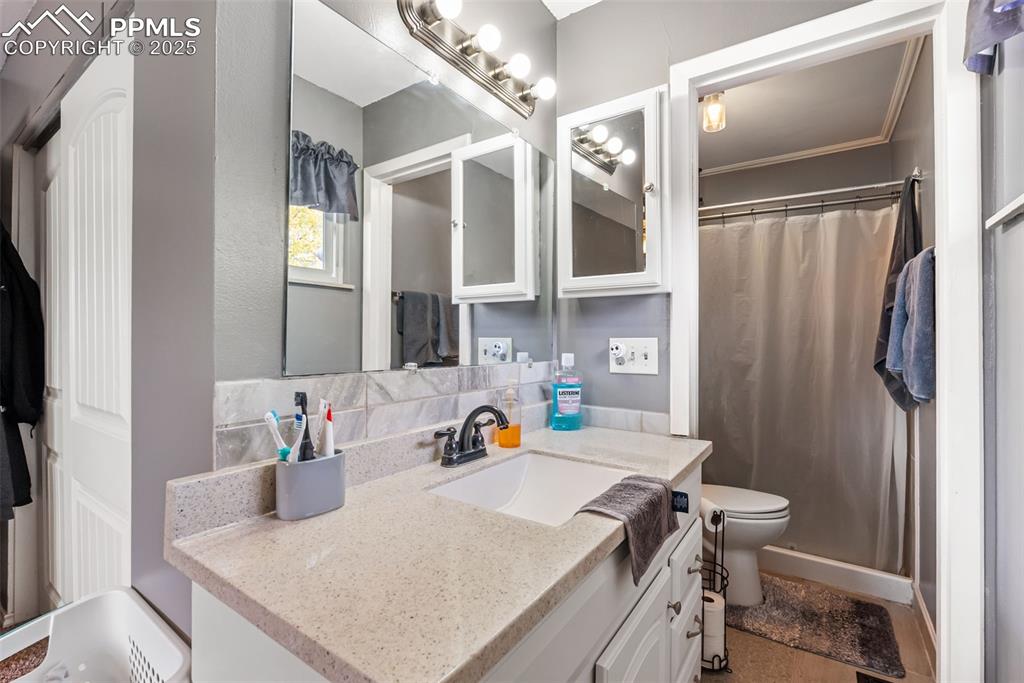 Image 22 of 50: Full bathroom featuring vanity, a shower with curtain, and backsplash