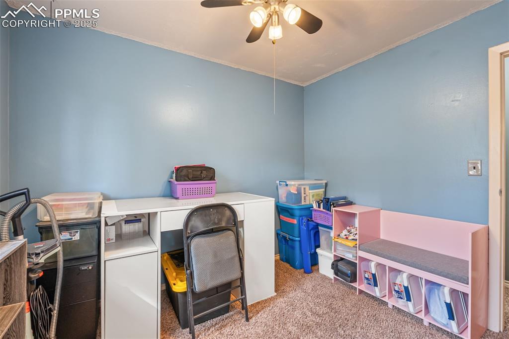 Image 26 of 50: Carpeted home office featuring ornamental molding and ceiling fan
