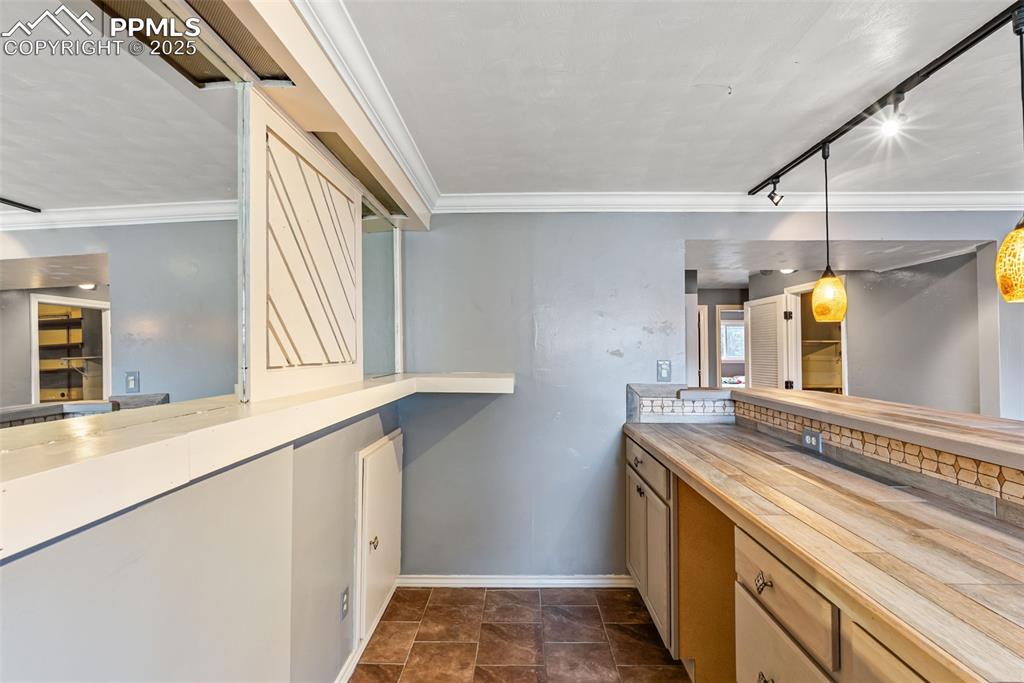 Image 35 of 50: Kitchen featuring ornamental molding, rail lighting, and pendant lighting