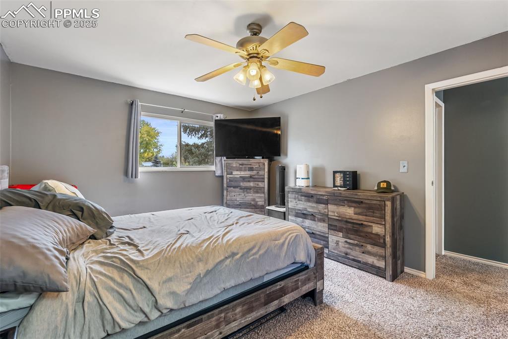 Image 40 of 50: Carpeted bedroom featuring a ceiling fan and baseboards