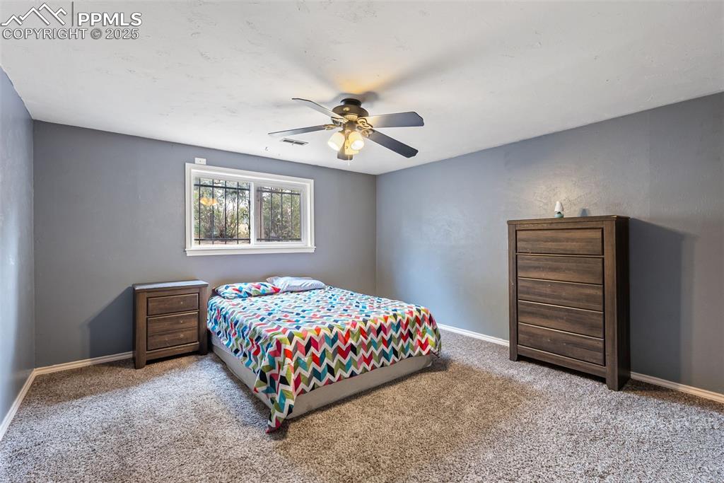 Image 42 of 50: Carpeted bedroom with baseboards and a ceiling fan