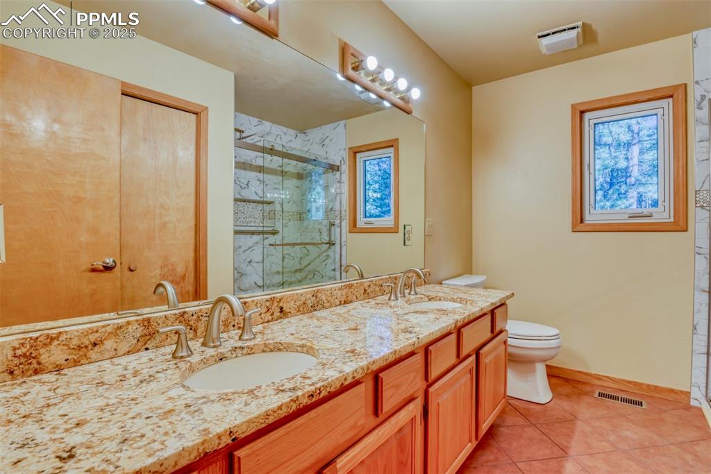 Image 13 of 23: Main-level bathroom with newly remodeled shower with barn doors