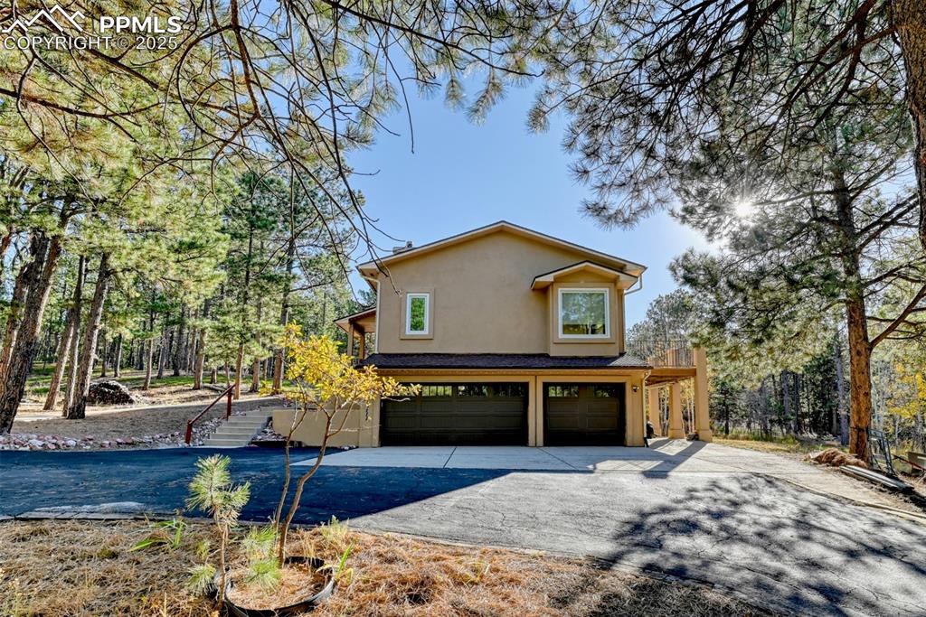 Image 21 of 23: Newer garage doors with circular driveway