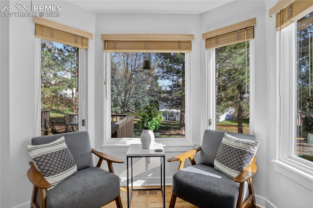 Image 18 of 47: Bay window with handsome wood look blinds looks out on mature landscaping a