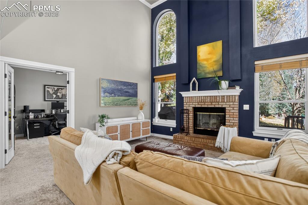 Image 21 of 47: The den has incredible light, brick fireplace,