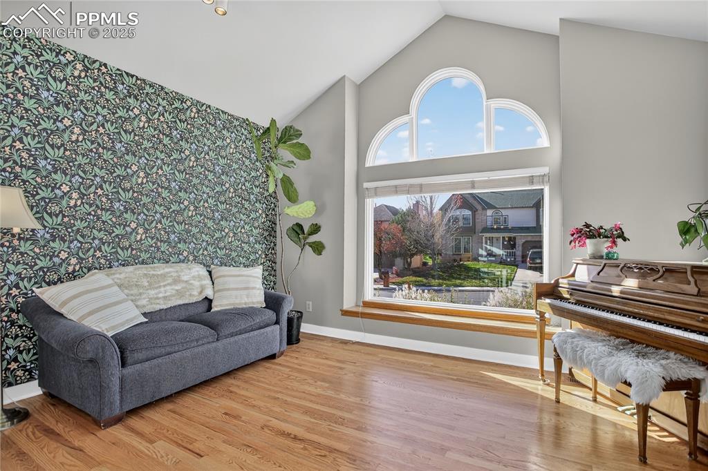 Image 8 of 47: Vaulted ceilings, stylish wallpaper accent wall, and wood flooring