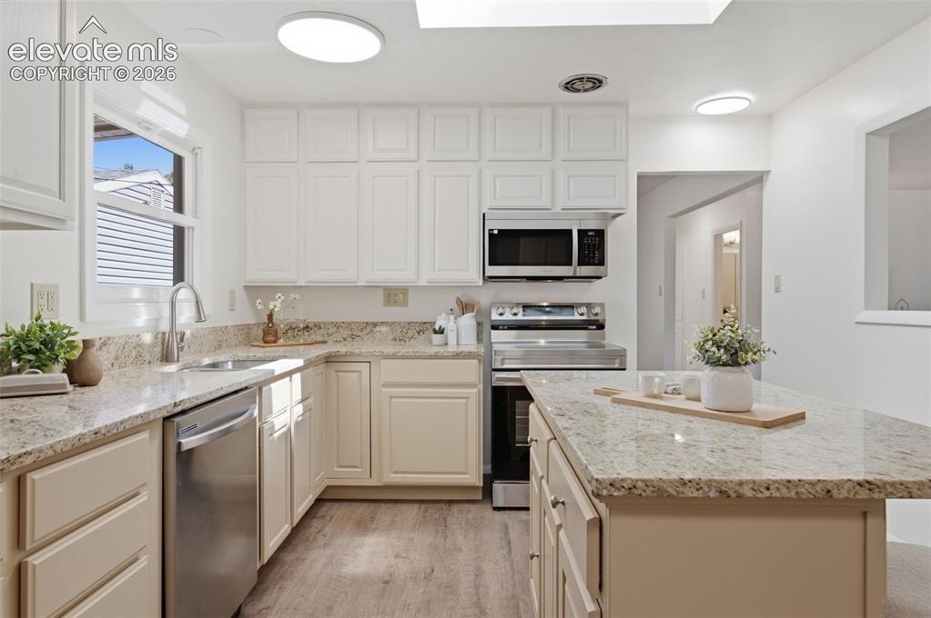 Image 15 of 34: Kitchen featuring white cabinetry, stainless steel appliances, granite coun