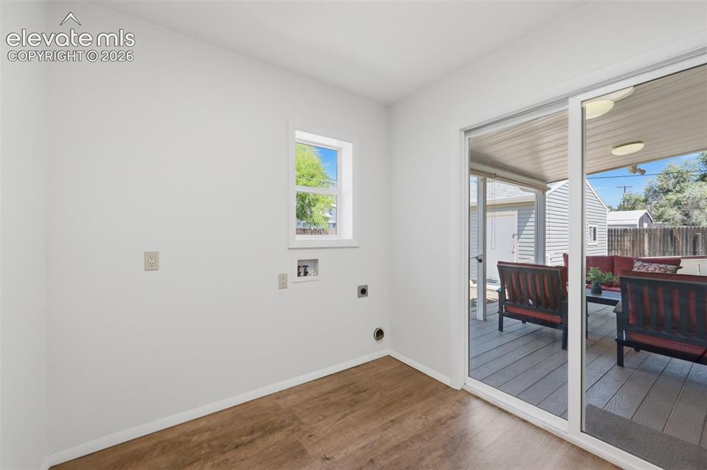 Image 17 of 34: Wood-finish flooring, white walls, and a window with white trim
