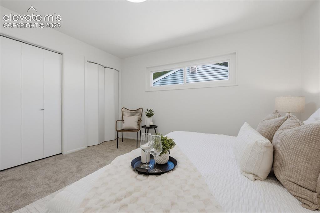 Image 22 of 34: White walls, light-toned carpeting, two bi-fold closet doors, and a horizon