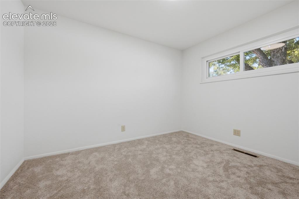 Image 23 of 34: White walls and neutral carpet