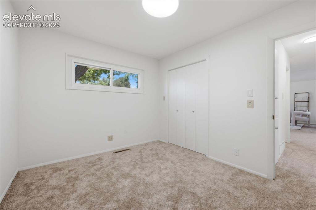 Image 24 of 34: White interior walls, neutral carpet flooring, horizontal sliding window, a