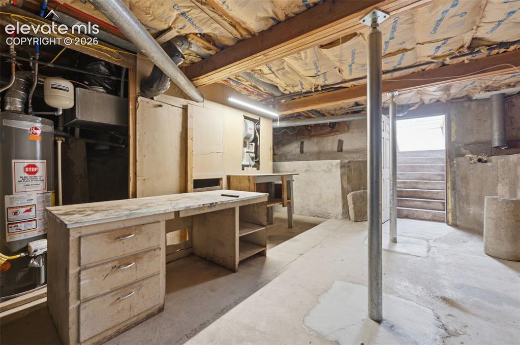 Image 33 of 34: Basement utility area featuring a water heater, exposed wood beams, concret