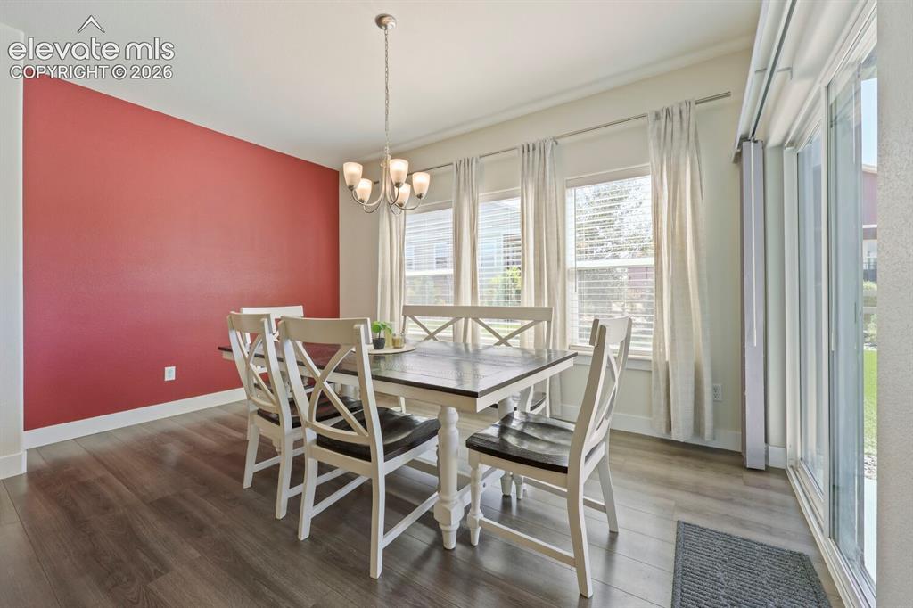 Image 10 of 45: Dining area featuring a maroon accent wall and lvp flooring