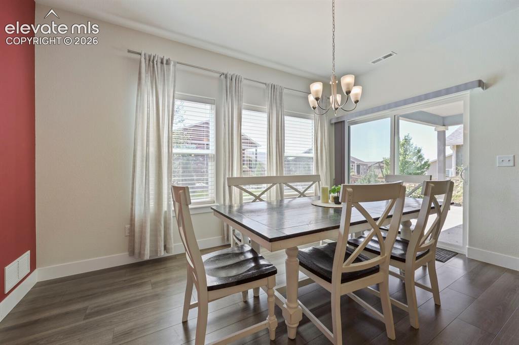 Image 11 of 45: Dining area featuring wood-finish flooring, a contemporary chandelier, mult