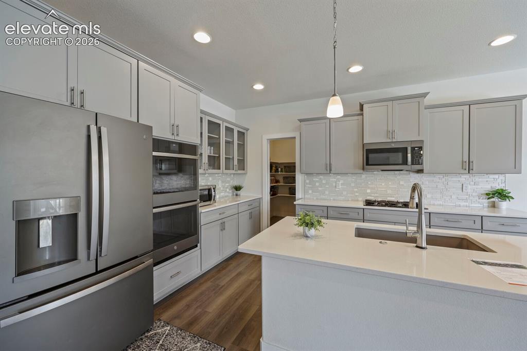 Image 15 of 45: Modern kitchen featuring a large central island with an undermount sink and