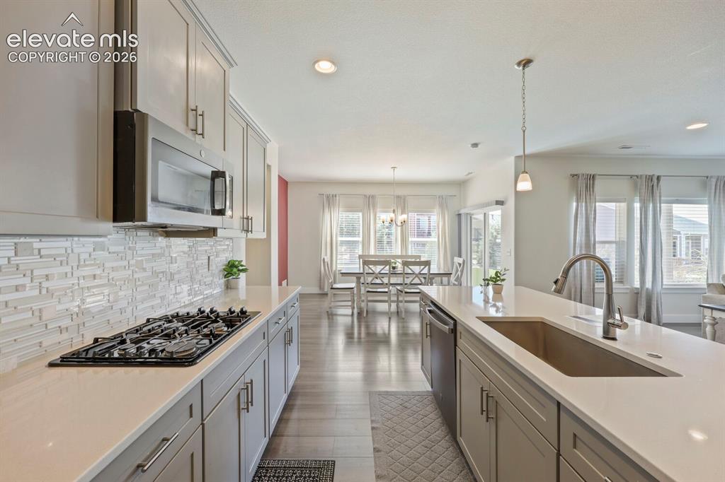 Image 17 of 45: Modern kitchen featuring light gray cabinetry, stainless steel appliances,