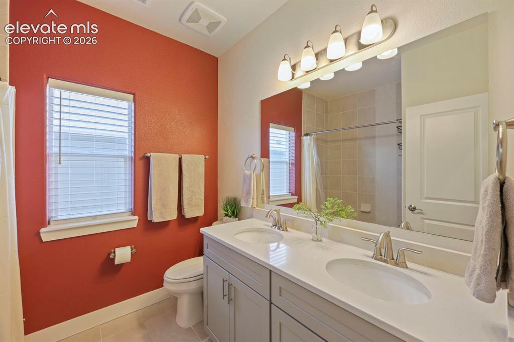 Image 25 of 45: Bathroom featuring a dual vanity with undermount sinks, light-toned counter