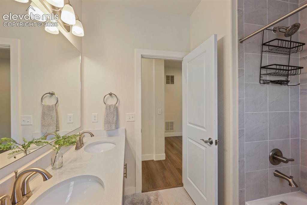 Image 26 of 45: Bathroom featuring a double vanity with undermount sinks, brushed nickel fi