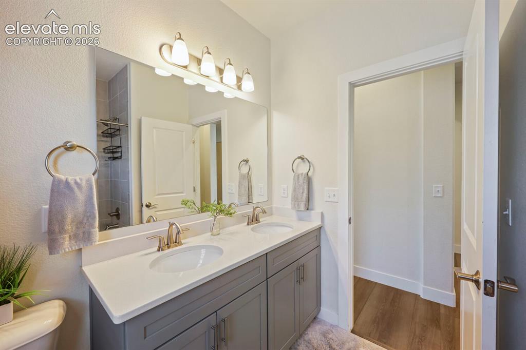 Image 27 of 45: Double vanity with undermount sinks, light gray cabinetry, and a light-tone