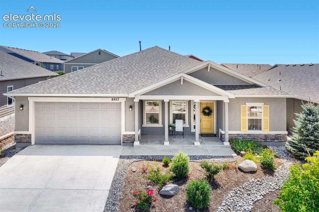 Image 3 of 45: Ranch-style residence featuring a gray exterior with stone accents, a cover