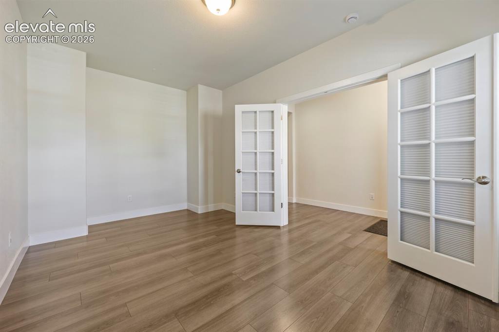 Image 30 of 45: Room featuring wood-finish flooring, white baseboards, and neutral wall ton