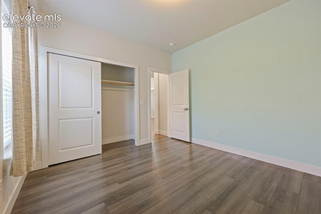 Image 34 of 45: Spacious room featuring wood-finish flooring, a double-panel sliding closet