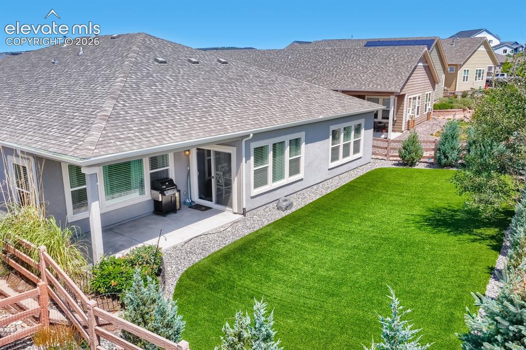 Image 42 of 45: Rear exterior featuring a covered patio, a sliding glass door, multiple lar