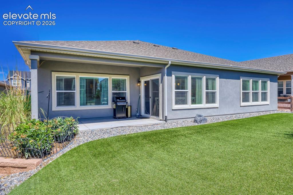 Image 43 of 45: Rear exterior featuring a covered concrete patio, sliding glass door, multi