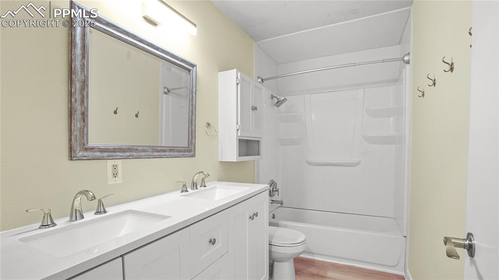 Image 18 of 25: Full bathroom with shower / washtub combination, double vanity, and light w