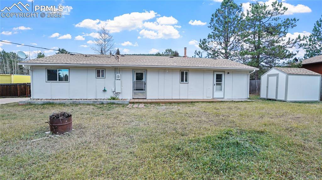 Image 20 of 25: Back of house with board and batten siding, roof with shingles, and a stora