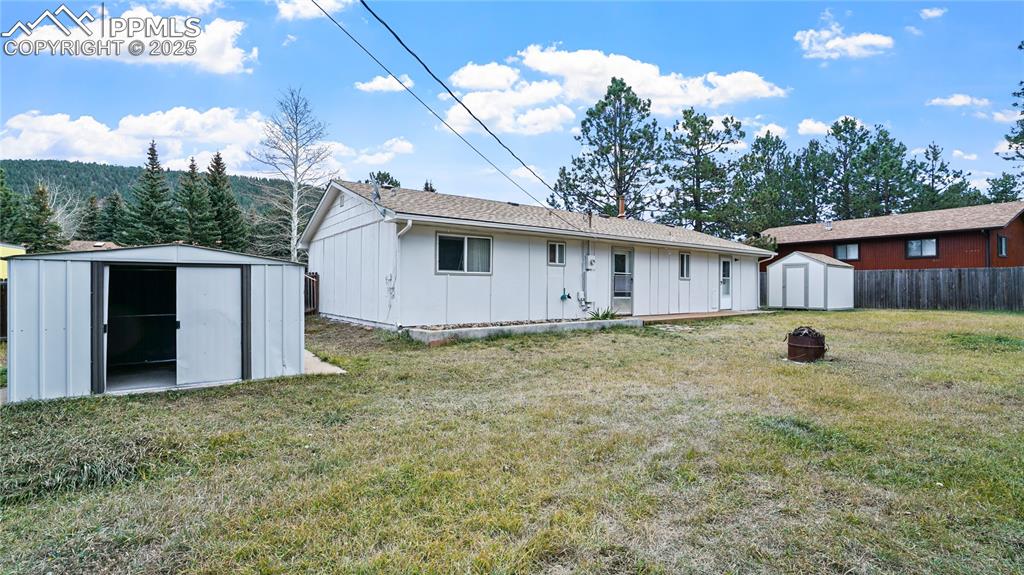 Image 21 of 25: Back of property featuring a shed, board and batten siding, and roof with s