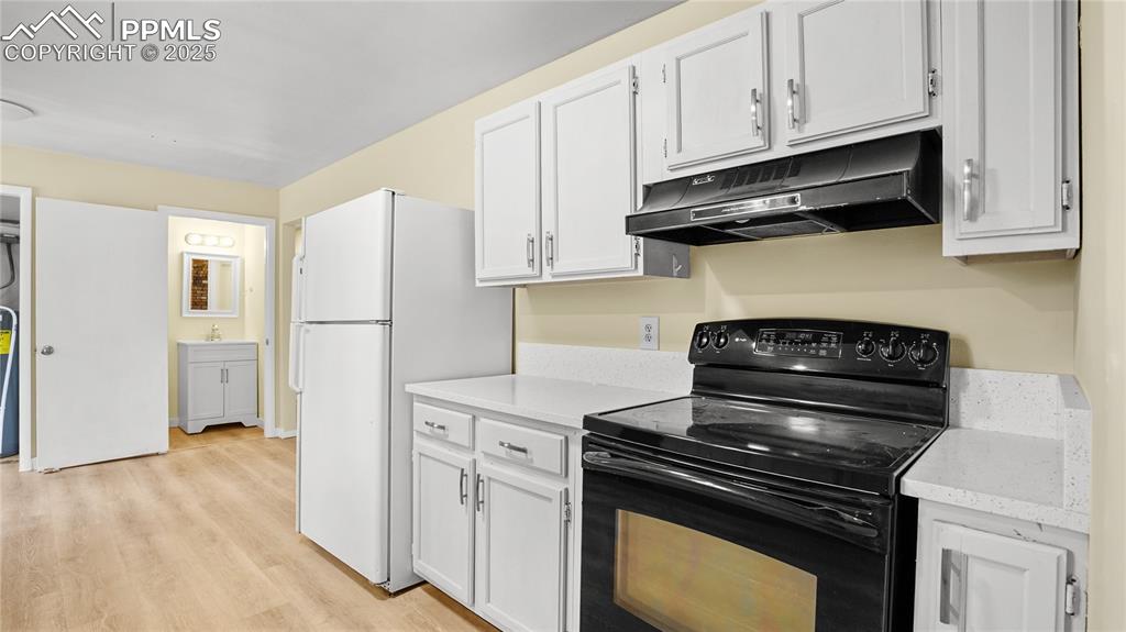 Image 7 of 25: Kitchen featuring black electric range oven, light countertops, freestandin